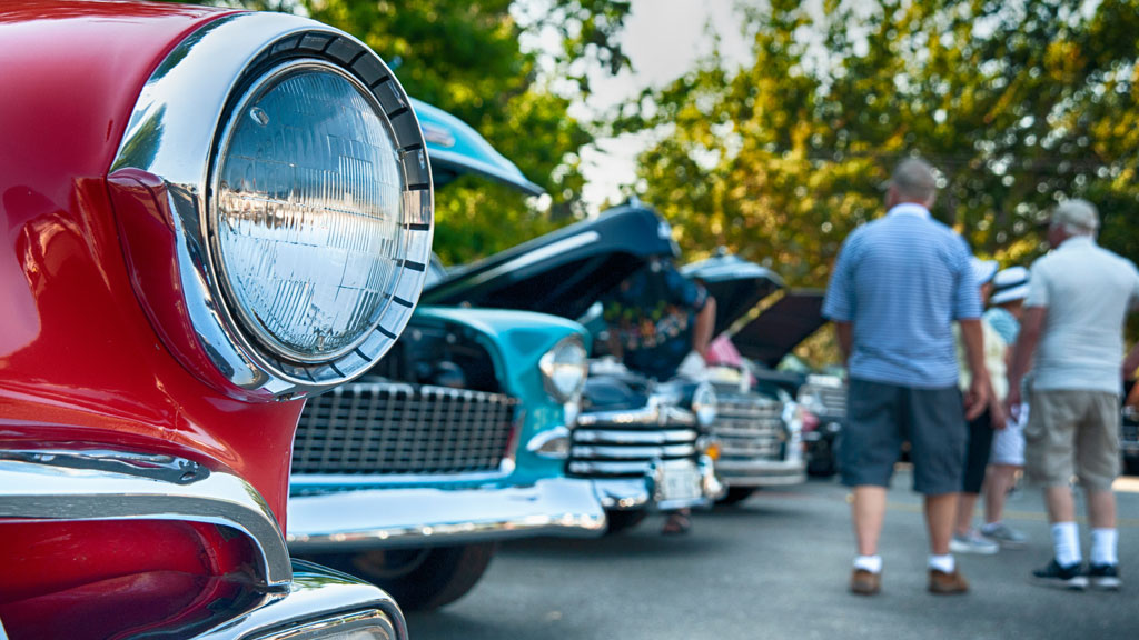 Rassemblement de voitures de collection avec propriétaires discutant lors d'un événement